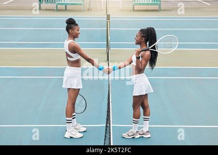 Two women handshake after tennis match. Young friends greet each other before tennis practice. African american athletes bonding after a tennis match Stock Photo