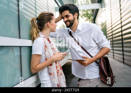 Two young successful business colleagues talking, working together outdoors. Stock Photo