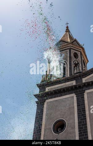 Confetti explodes from a church tower to celebrate the local saint's day in the small town of Trecastagni, near Catania, Sicily Stock Photo