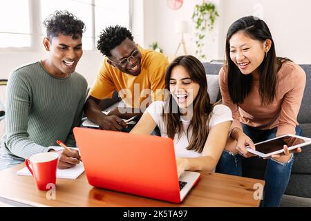 Young group of diverse students studying together using laptop at home Stock Photo