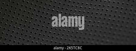 Black leather fabric pattern of small holes, wallpaper Stock Photo