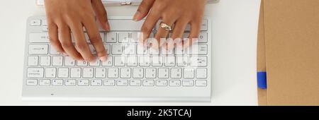 Beautiful hands of a dark-skinned woman on a keyboard Stock Photo