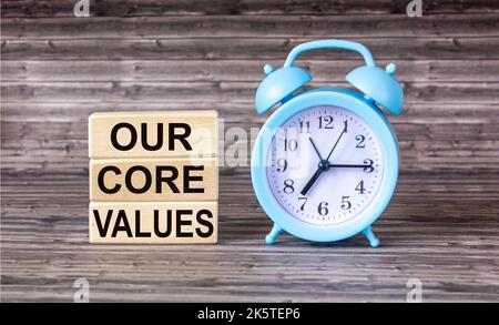 Conceptual words Our Core Values on wooden blocks on wooden background with clock. Business value and our concept of core values. Copy space. Stock Photo