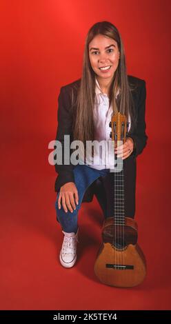 Beautiful young woman playing a CUATRO, typical Venezuelan instrument. Recording session, Concept of music and typical instruments. Stock Photo