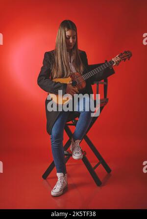 Beautiful young woman playing a CUATRO, typical Venezuelan instrument. Recording session, Concept of music and typical instruments. Stock Photo