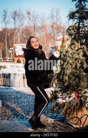 Beautiful girl in a Ukrainian national scarf in winter on the street Stock Photo