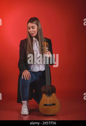 Beautiful young woman playing a CUATRO, typical Venezuelan instrument. Recording session, Concept of music and typical instruments. Stock Photo