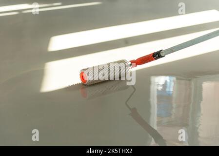 Needle roller for self-leveling floors. Leveling the floors with a cement mixture. Stock Photo