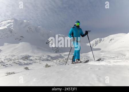 Male backcountry skier hiking to the summit of a snowy peak in the Low Tatras in Slovakia. Stock Photo