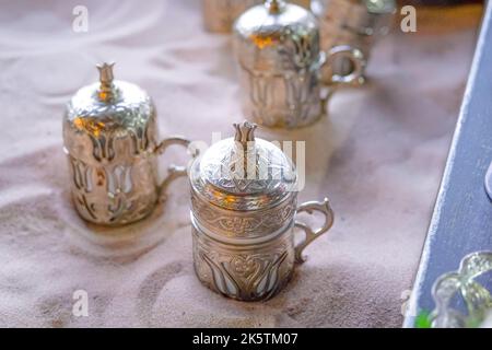 Copper cups with Turkish coffee cooked in hot sand. Stock Photo