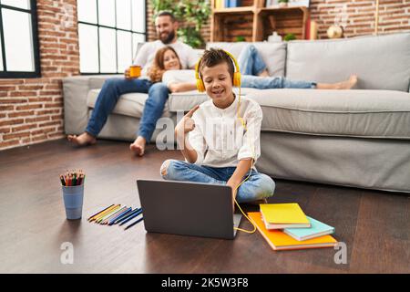 Family of three doing homework at home smiling happy pointing with hand and finger Stock Photo