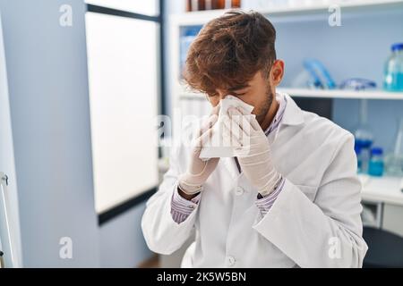Young arab man scientist using napkin at laboratory Stock Photo