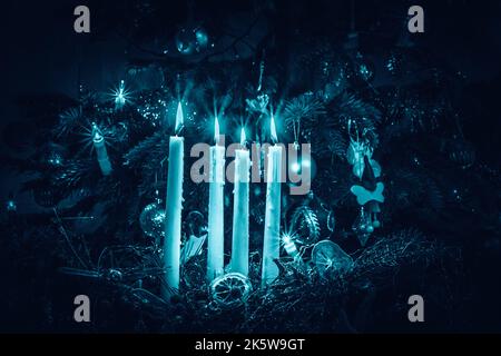 yellow advent candles on black background blue tone Stock Photo