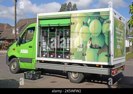Asda supermarket green home shopping delivery van unattended open side street view crate racks with pre ordered online grocery food Essex England UK Stock Photo