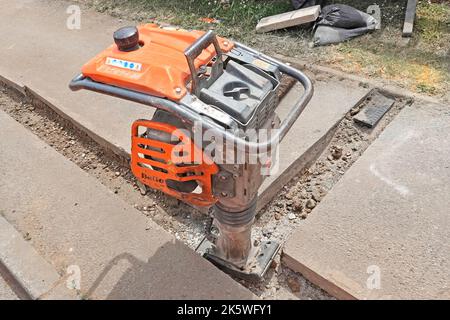 Broadband infrastructure construction project main trench & house cable spur junction box close up of mechanical vibrating compaction machine Essex UK Stock Photo