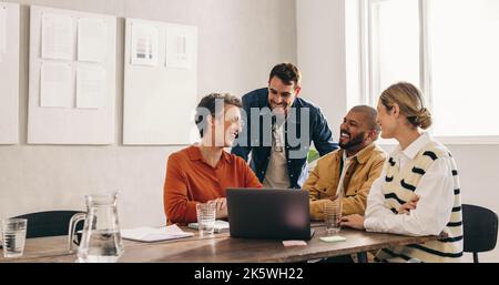 Cheerful designers smiling happily while having a meeting in an office. Group of successful businesspeople working on a new interior design project in Stock Photo