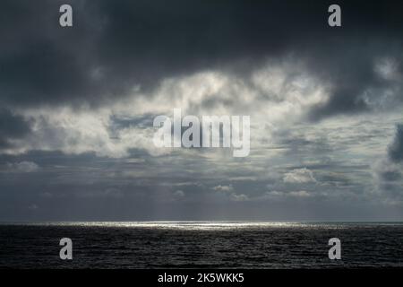 Incredible storm at sea. Sun rays breaking through the dark clouds. Stock Photo