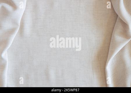 White crumpled linen fabric texture background. Natural off white wavy linen organic eco textiles canvas background. Top view Stock Photo