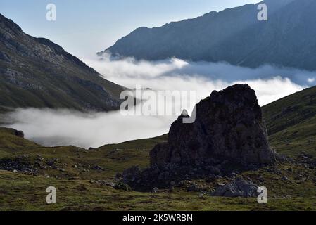 A bank of cloud moving in between the eastern and central massifs (Macizo Oriental and Macizo Central) of the Picos de Europa, Spain, with outctrop. Stock Photo