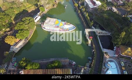 A high-angle shot of the Sengkaling waterpark with a colorful boat in the water in Malang city Stock Photo