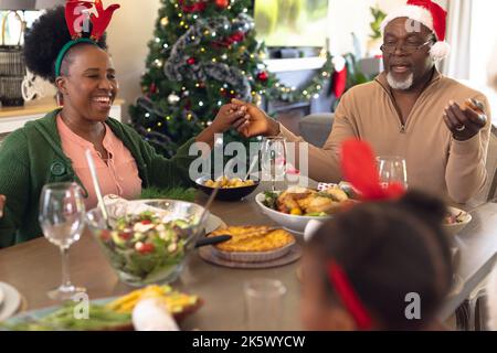 Happy african american family praying before having christmas meal Stock Photo