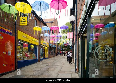Bright coloured umbrellas in the Coppergate area of York Stock Photo
