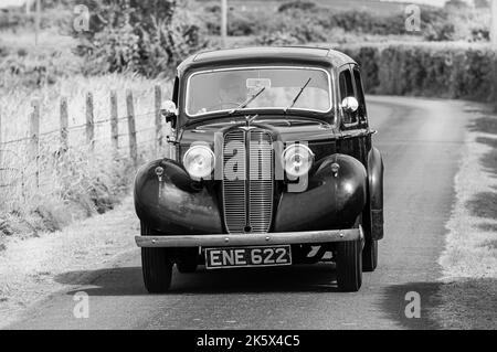 1938 Hillman Minx drives down a very narrow rural road. Stock Photo