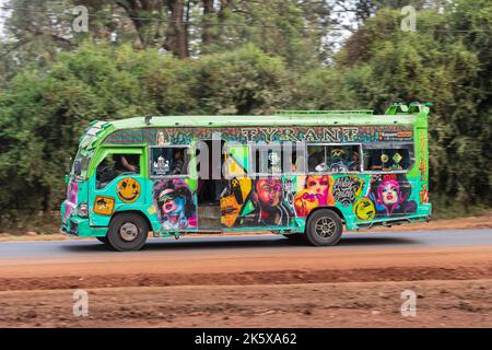 A bus with custom paintwork driving along Ngong road near the junction with Oloolua Close. Many buses in Nairobi have custom paintwork, a wide range o Stock Photo