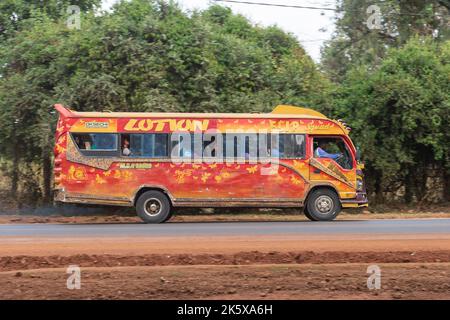 A bus with custom paintwork driving along Ngong road near the junction with Oloolua Close. Many buses in Nairobi have custom paintwork, a wide range o Stock Photo