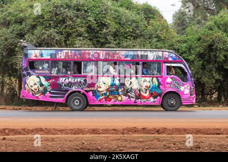 A bus with custom paintwork driving along Ngong road near the junction with Oloolua Close. Many buses in Nairobi have custom paintwork, a wide range o Stock Photo