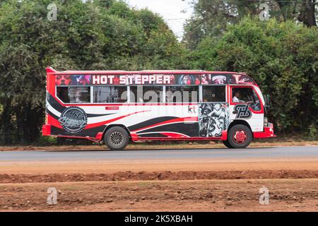 A bus with custom paintwork driving along Ngong road near the junction with Oloolua Close. Many buses in Nairobi have custom paintwork, a wide range o Stock Photo