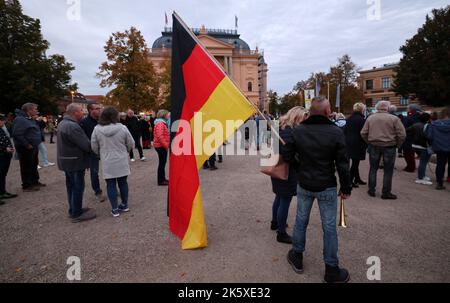 Schwerin, Germany. 10th Oct, 2022. Participants gather in the Old Garden for a demonstration against the energy policy in the Northeast, one man has a large German flag with him. Credit: Bernd Wüstneck/dpa/Alamy Live News Stock Photo