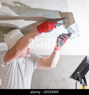 Application of lime plaster on the ceiling, repair work with environmentally friendly lime, overhaul of the room. Stock Photo