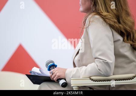 Crop female speaker with microphone on stage Stock Photo