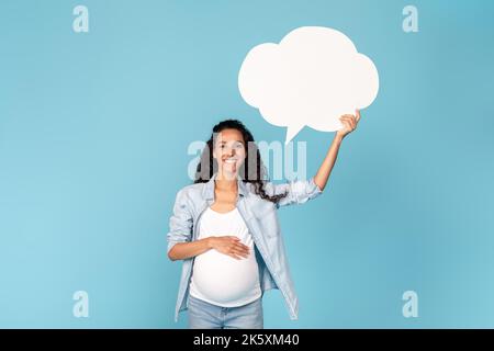 Happy millennial pregnant arab woman with belly holding abstract cloud buble with copy space Stock Photo