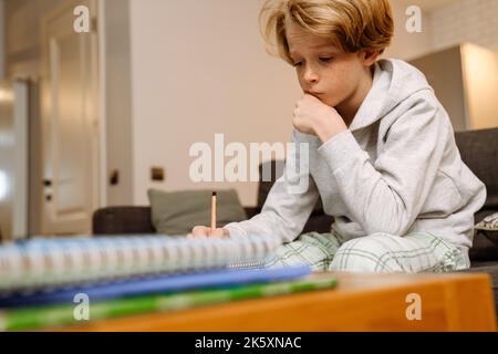 Ginger boy using laptop while doing homework with his father at home Stock Photo