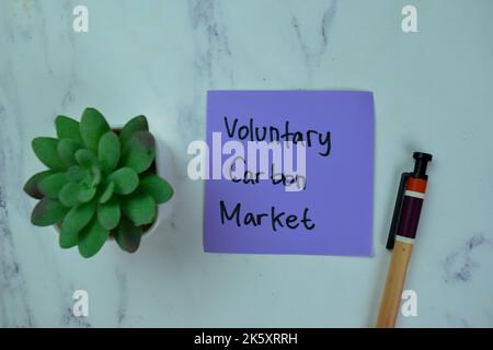 Concept of Voluntary Carbon Market write on sticky notes isolated on Wooden Table. Stock Photo