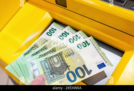 Depositing and withdrawing cash euro banknotes from an ATM. Economic and financial concept Stock Photo