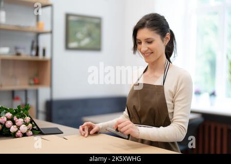 Florist working with flowers making a composition Stock Photo