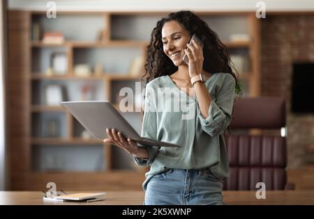 Cheerful woman entrepreneur working at home office Stock Photo