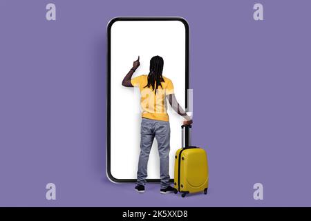 Back view of black man tourist using big smartphone, mockup Stock Photo