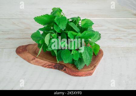 Mint. Bunch of fresh green organic lemon balm on wooden table closeup Stock Photo