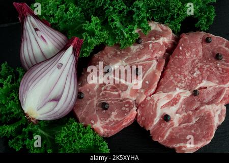 Raw Pork Chops with Pepper and Rosemary  on   dark background Stock Photo