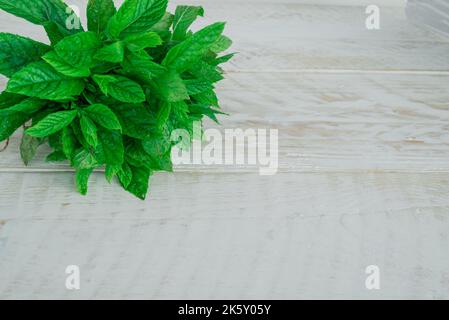Mint. Bunch of fresh green organic mint leaf on wooden table closeup Stock Photo