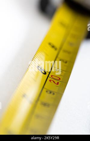 Yellow tape measure showing 8 inches and 20 centimeters Stock Photo