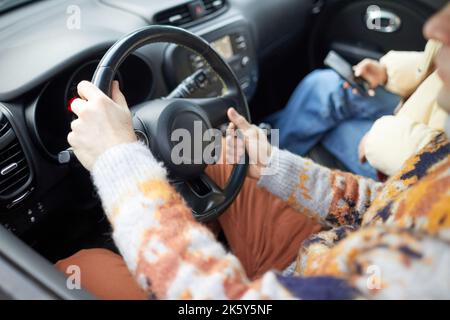 Close up of young woman driving car in winter, focus on female hands on wheel, copy space Stock Photo