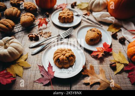 Close up of small autumn shaped pumpkin spice cakes on plates. Stock Photo