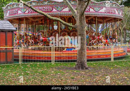 Fairground at Parsons Green, West London, UK; super-bright coloured rides, balloons, cars, trains and Spiderman Stock Photo