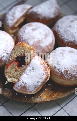 Berliner donuts in powdered sugar on a wooden tray. Stock Photo