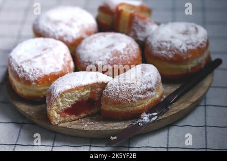 Berliner donuts in powdered sugar on a wooden tray. Stock Photo
